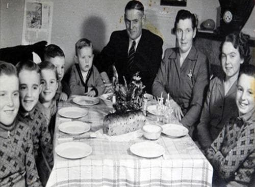 Familie aan tafel voor het kerstbrood